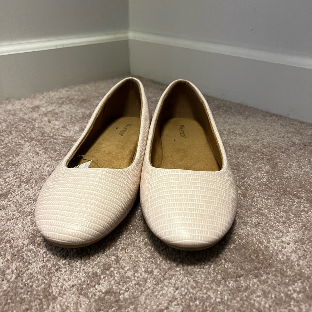 Cream colored textured ballet flat shoes.